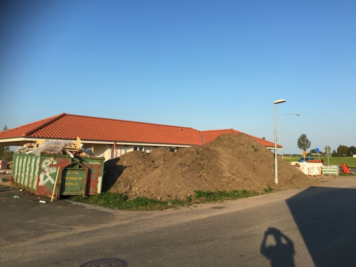 Högar av matjord bredvid byggnadsavfall i Klagshamn, Malmö, redo för bortskänkning.