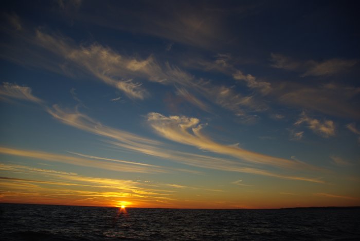 Solnedgång över havet med dramatisk himmel och vackra molnformationer nära Halland.