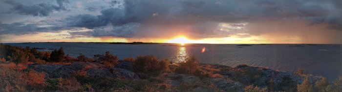 Panoramavy över solnedgång vid Söderarm, öster om Norrtälje, med hav och klippor.