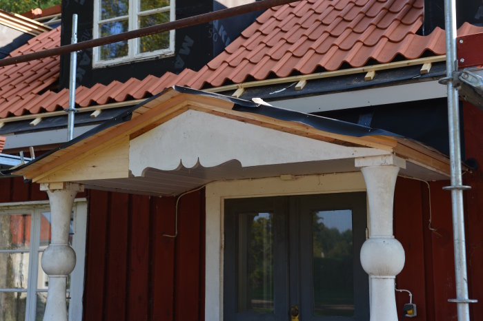 Renoverat entrétak med ny profil på vindskivor och takfotsbrädor, nytt läktat tak i bakgrunden.