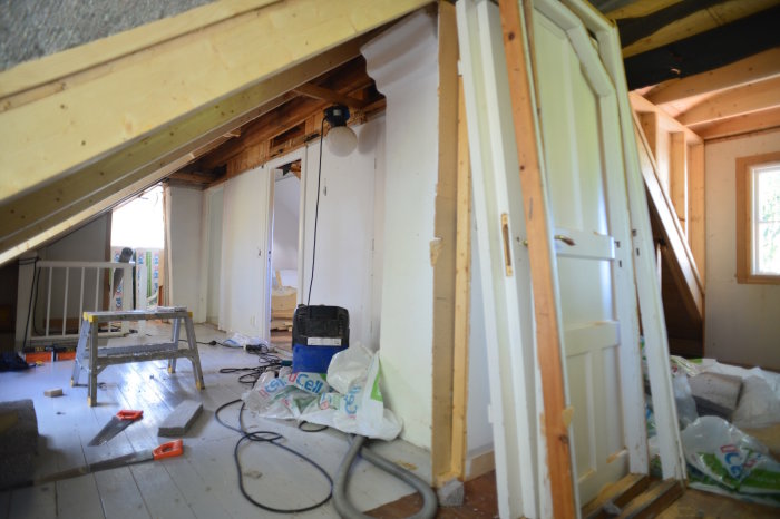 Renoveringsprojekt i ett hus med isoleringsmaterial och byggverktyg synligt, ej färdiga golv och väggar.
