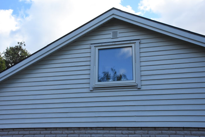 Nyinstallerad fjällpanel på hus med synligt fönster och borttagen ventil högst upp.