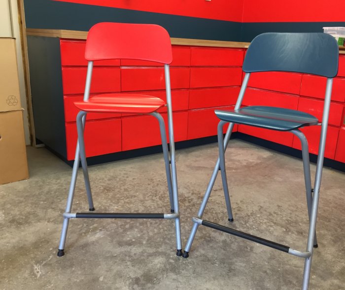 Renoverade Ikea-stolar i rött och blått mot en orange vägg.
