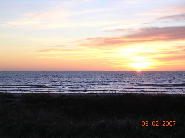 Solnedgång över havet med färgglad himmel, sett från Särdal.