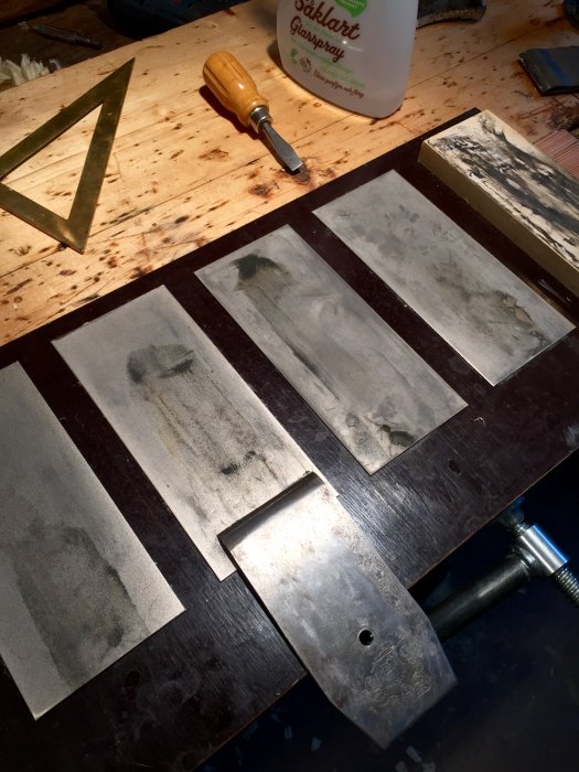 Arbetsbänk med olika grovlekar av diamantbrynen limmade på plywood, använda för slipning.