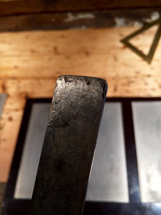 Närbild på ett stämjärns skarpa kant med diamantbrynen i bakgrunden.