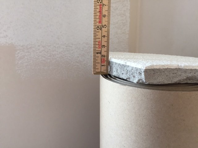 Tjocklek på sandgrängat betongtak mäts med tumstock som visar nedböjning på ca 1 cm.