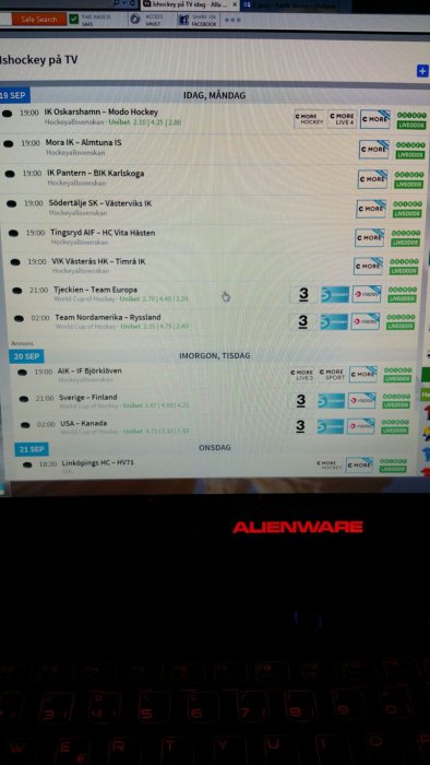 Skärmdump av hemsida som visar hockeymatcher på TV med Alienware laptop i förgrunden.