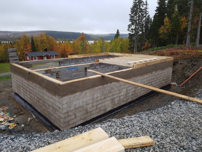 Halvfärdig soutterängkällare under konstruktion med Lecablock på en byggarbetsplats.
