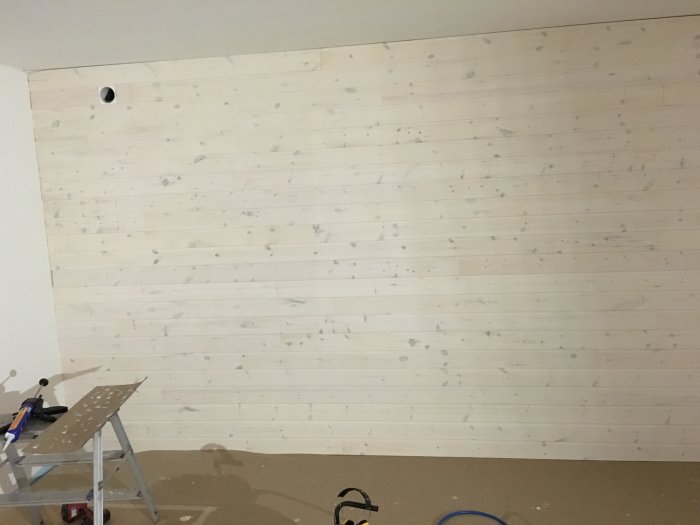 Nypanelad vägg med början på foder och infällda spotlights i taket.