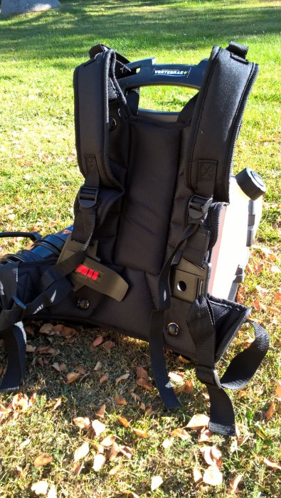 Ryobimaskin med anpassad förlängning på blåsröret, gjord av plastflaska, stödd mot grönt gräs med löv.