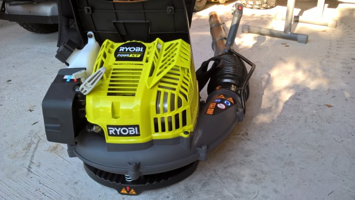 Ryobi lövblås med förlängt blåsrör av plastflaska, visar motor, sele och vibrationsdämpande fjädrar.