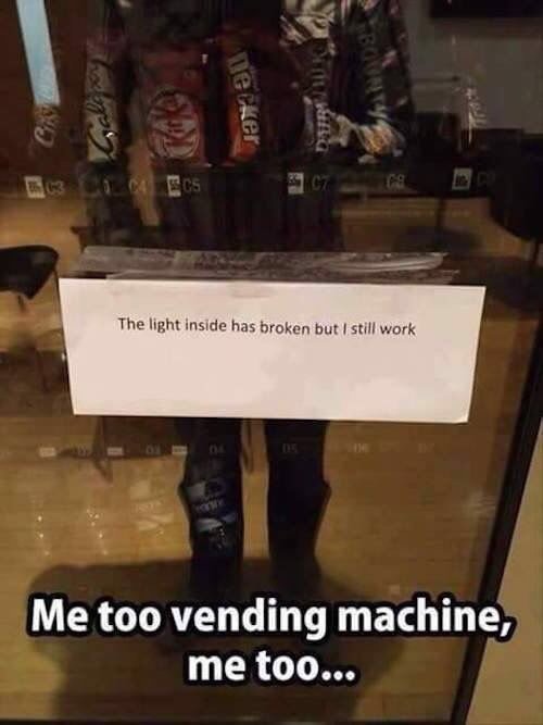 En varuautomat med ett skylt där det står "The light inside has broken but I still work", med reflekterande text "Me too vending machine, me too...".