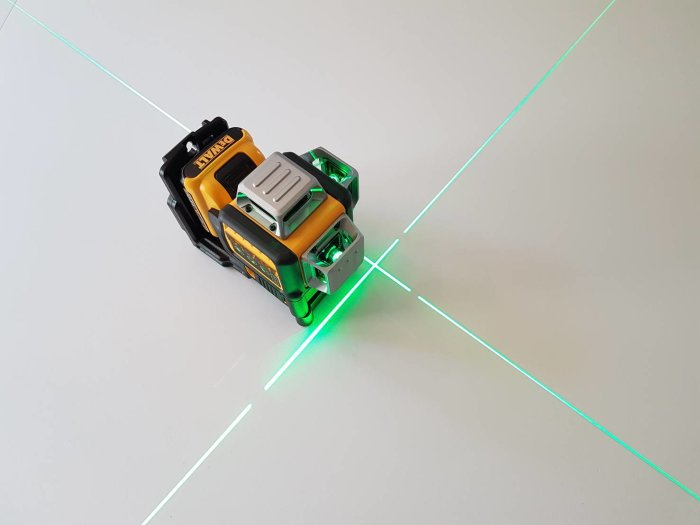 DeWalt verktygsbatteridriven laserprojektor som avger grön 360° laserlinje på en ljus yta.