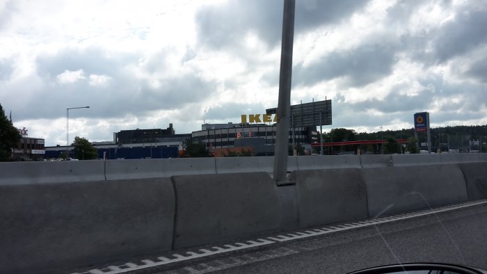 Vy från bil med IKEAs skylt och Statoil bensinstation i bakgrunden, tagen vid bilkörning.