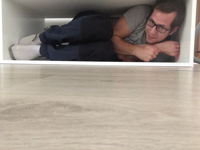 Person demonstrerar storlek på fack genom att ligga i det.