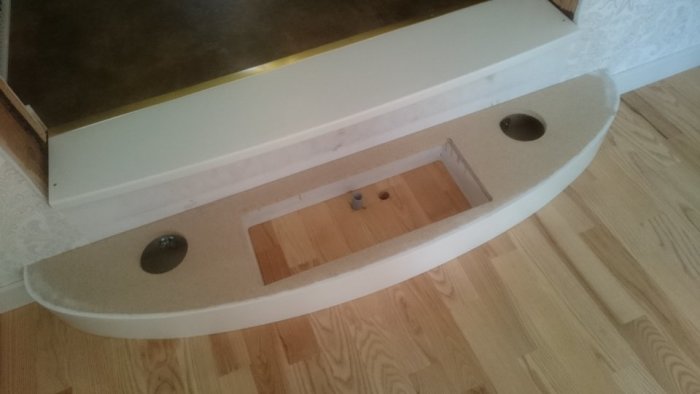 Nybyggd prototyp av en trappa i ljusa material mot ett trägolv.