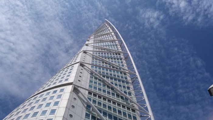 Modern arkitektur i Västra hamnen med Turning Torso mot en klarblå himmel med spridda moln.