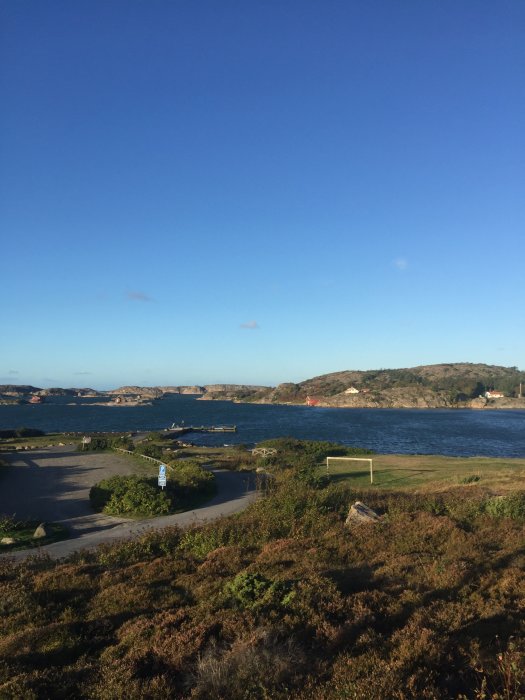 Vy över kustlandskap i Grebbestad med vågigt hav och klar himmel under storm.