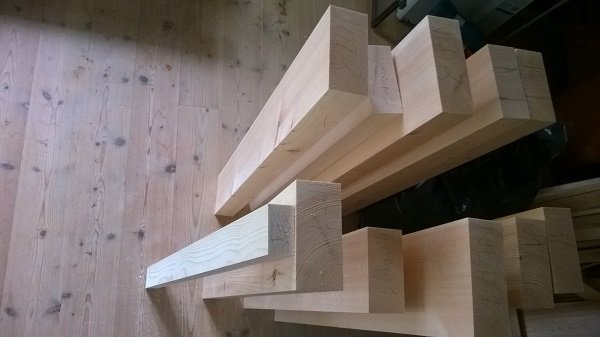 Grovdimensionerade träkarmämnen till stallfönster på trägolv.