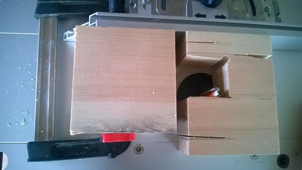 Träkarmämne med grovkapad slits och synliga sågmärken vid en arbetsbänk.