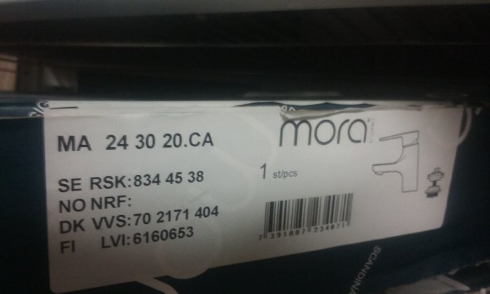 Etikett på förpackning med en tvättställsblandare från Mora I-line och en bottenventil, inkluderar produktkoder och streckkod.
