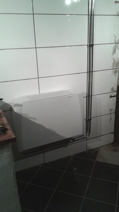 Nyinstallerad fläktkonvektor med kromade och alupex rör, ersätter ett gammalt element.