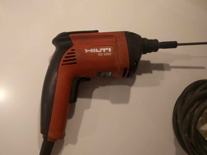 Begagnad Hilti SD 5000 skruvautomat i acceptabelt skick på ett vitt bord.