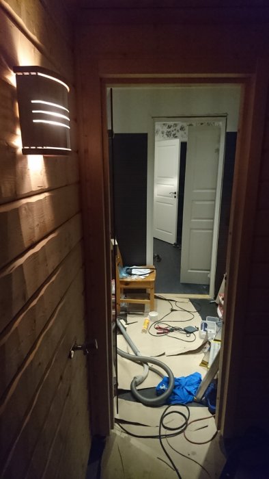 Interiör av bastu under konstruktion med synlig timmerpanel och en högtalare installerad ovanför dörren.