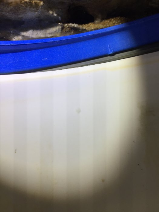 Närbild av randiga ljusskuggor på vit yta orsakade av LED-lampa med blå detalj.
