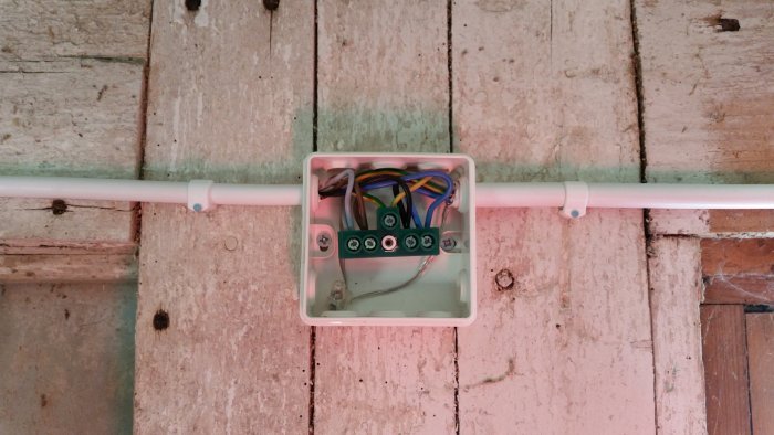 Elrör EXLQ installerat på en vägg med öppen dosa där flera färgglada elkablar är anslutna.