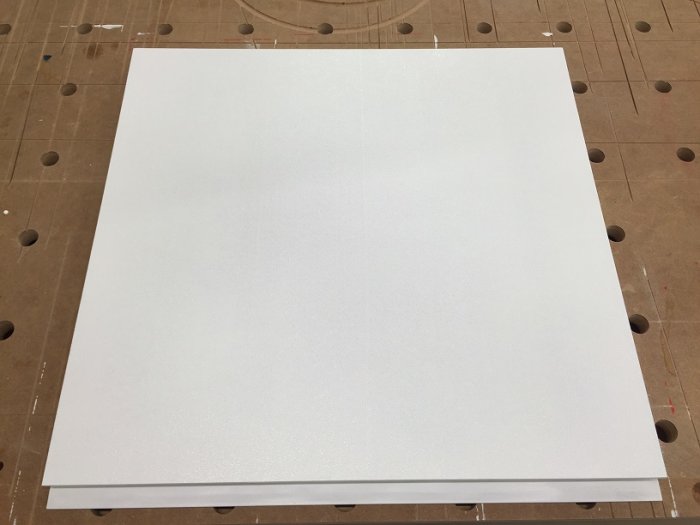 Målad och nyslipad vit köksfronter i MDF på ett verktygsbord med hål.