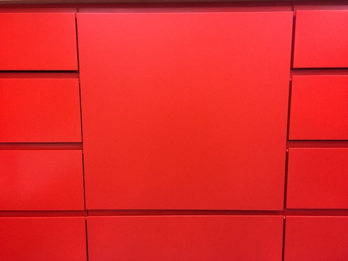 Rödmålade MDF-skåpsfronter med fingergrepp, slipade och målade, monterade på björkplywood lådor.