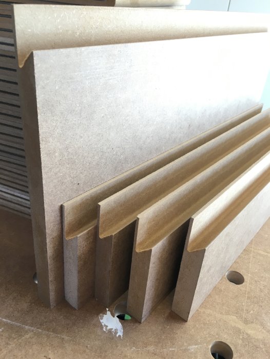 Obehandlade MDF-lådfronter staplade ovanpå varandra, med synligt släta ytor och distinkta kanter.