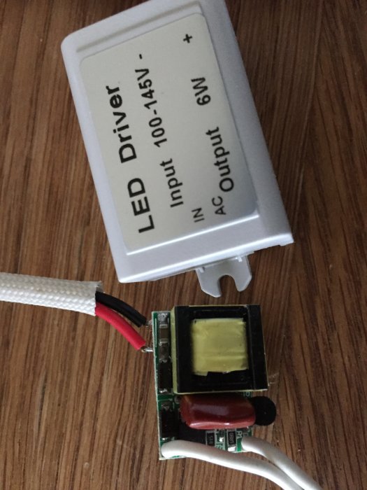 LED-driver för 110V öppnad med synlig kretsuppställning och anslutningskablar.