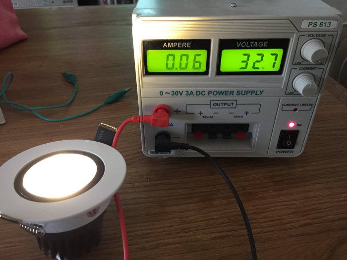 LED-spot ansluten till en digital Power Supply som visar 32.7V och 0.06A på displayerna.