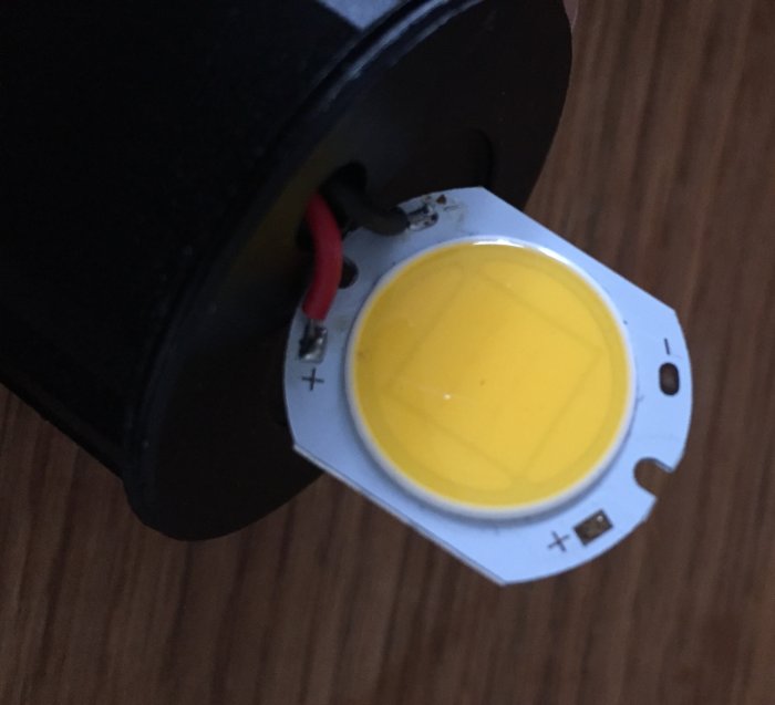 LED-diod monterad i armatur utan synlig märkning, röd och svart kabel ansluten.