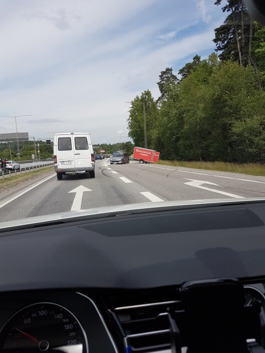 Vägvy med en släpvagn från Bauhaus som står vid sidan av en trafikerad väg.