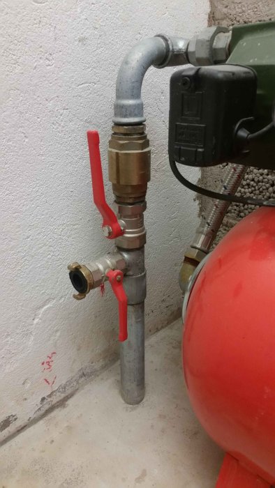 Rörinstallation med ventilpaket och krokopplingar anslutet till en röd tank.