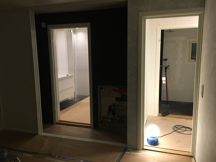 Nyinstallerade vita garderobsdörrar och en renoverad toalett utan toalettlock syns i en husrenovering.