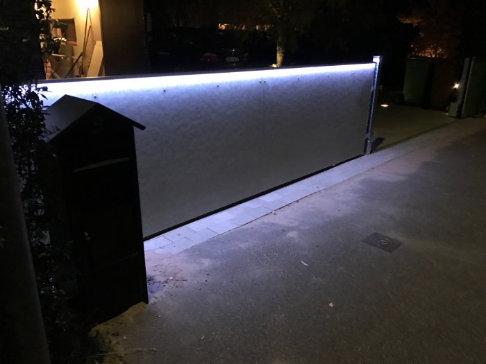 Aluminiumlister med LED-profil monterade längs en uteplats, upplyst i mörkret.