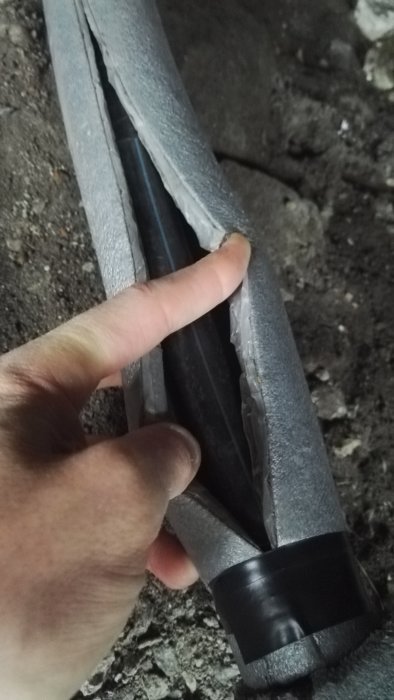 Hand visar isolerat vattenrör med skumplast och frostguard värme slinga.