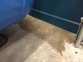 Hörn av ett rum utan golvlist med synlig vägg och golv övergång, skräp på golvet.