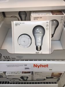 IKEA TRÅDFRI LED lampa E27 i butikshylla med skylt för nyhet och pris.