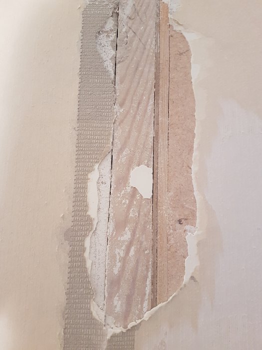 Skadad vägg där betong möter gips och material lossnar, behöver renoveringstips.