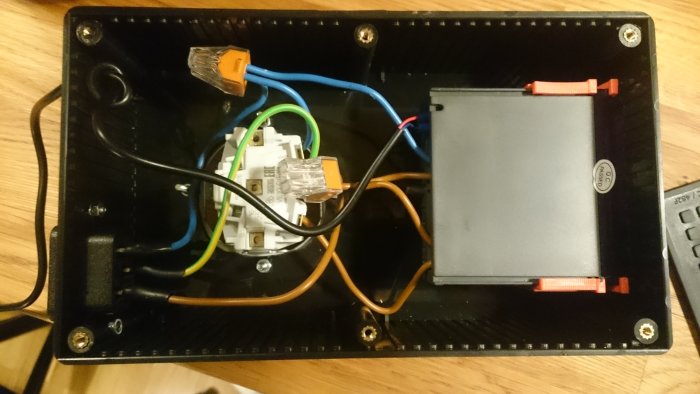 Eluttag monterat i en svart låda med synliga kablar och anslutningar.