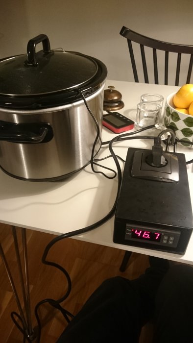 En slow cooker kopplad till en energimätare som visar 467 watt på köksbänken.