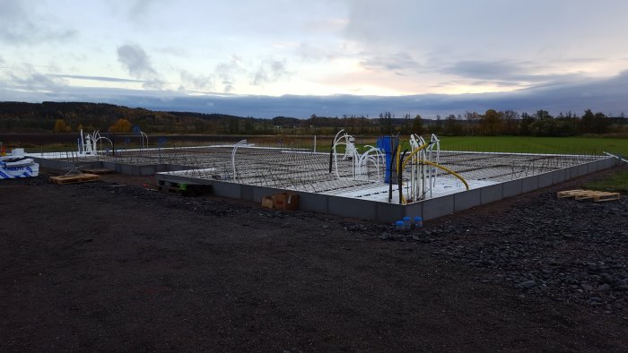 Förberedelse av byggplatta med armeringsjärn och rörgenomföringar inför betonggjutning.