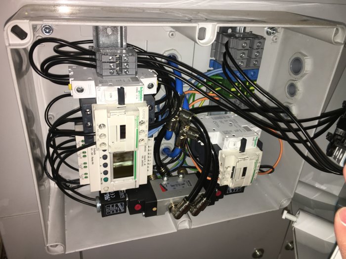 Inre del av en spånsug med elektriska komponenter och kablar, före underhåll av filtret.