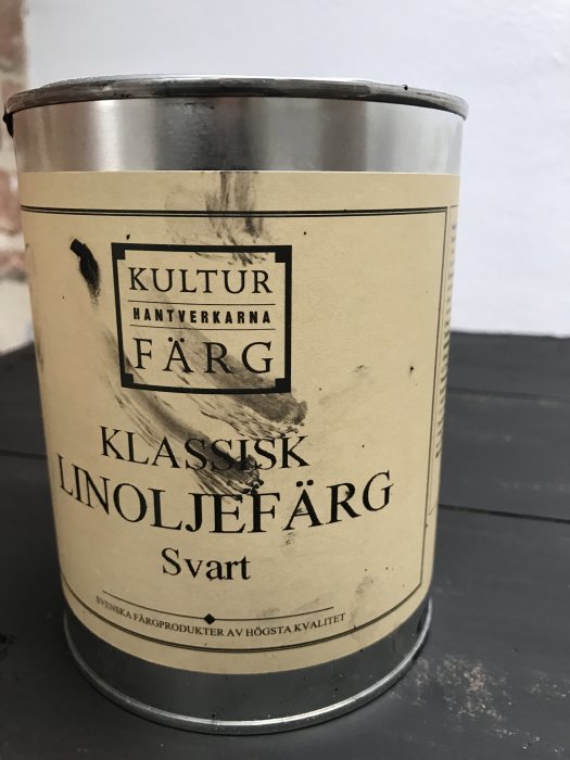 Burk med Kulturhantverkarna klassisk linoljefärg i svart på ett bord.